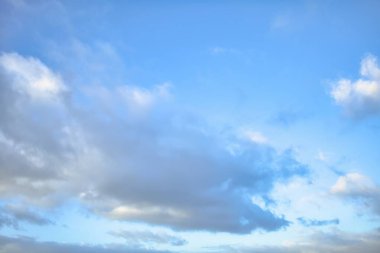 Arkalarında açık mavi gökyüzü olan açık gri kabarık bulutların gökyüzü yedeği.
