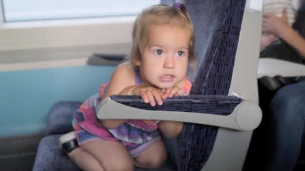 Μικρό Κοριτσάκι Που Παίζει Κοιτάζοντας Έξω Από Παράθυρο Στα Τρεχούμενα — Αρχείο Βίντεο