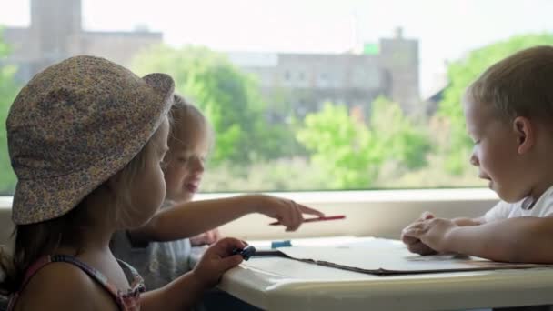 三个快乐的孩子正在乘火车旅行 度假的小游客 环游世界 在夏天的旅行中 小朋友们正在画画 梦想着什么 — 图库视频影像