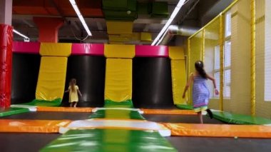 Playroom 'da koşuşturan Küçük, Sevimli Tamirci Kızlar. Çocuklar Trambolinde Atlıyor Çocuk Eğlence Merkezi 'nde. Çocuk parkında eğleniyor. Çocukluk, Geliştirme, Eğlence Konsepti