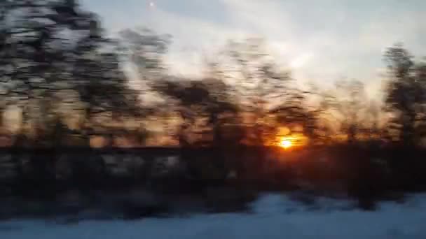 从高速列车的窗口眺望美丽的大自然 狂野的雪地 寒冷的田野和光秃秃的树木 在冬日的夕阳西下 铁路概念 — 图库视频影像