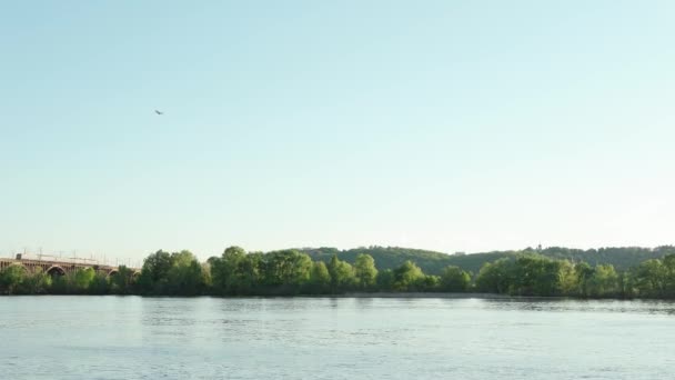观看日落时分在第聂伯河上移动渔船的景象 城市湖上的工业桥梁景观 在阳光明媚的夏日 火车和平原经过池塘 水路通畅 — 图库视频影像