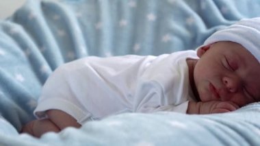 Yakın plan Yeni Doğmuş Bebek Yüzü İlk Günler Mavi Yıldızlı Arkaplanda Tatlı Uyuyor. Hayata Başlayan Çocuk Şapka 'da. Bebekler, Doğum, Doğumun İlk Anları, Başlangıç Konsepti.