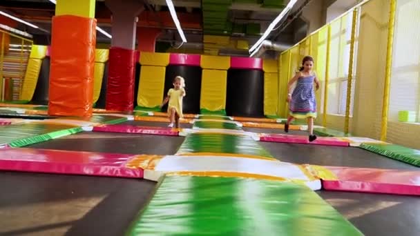 プレイルームで楽しく走るかわいいプリスクールタイガーの女の子 子供たちはキッズエンターテイメントセンターのトランポリンでジャンプします 子供は遊び場で楽しみを持っています 子供時代 レジャーの概念 — ストック動画