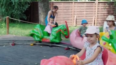 2021.08.12 - Kiev, Ukrayna: Küçük Okul Öncesi Çocuklar Dinozorlar veya Hayvanların Eğlencesi Şeklinde Trenlerle Çember İçinde Geziniyor. Dinopark 'ta Motorlu Dinozor Yırtıcı Model.