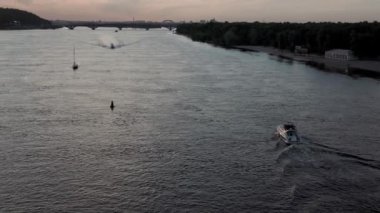 Üst hava manzaralı balıkçı teknesi okyanusu. Akşam Dnipro nehrinde gün batımında balıkçıyla motorlu tekne gezintisi. Kiev Ukrayna 'daki göllerin üzerindeki köprü manzarası. Su taşımacılığı, seyahat
