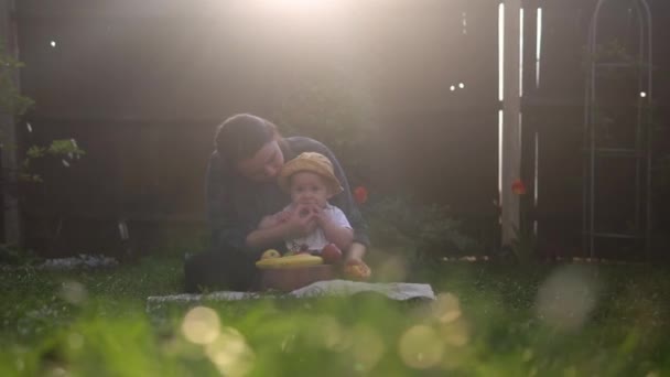 Šťastná Mladá Veselá Matka Drží Dítě Jíst Ovoce Zelené Trávě — Stock video