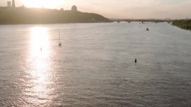 Üst hava manzaralı balıkçı teknesi okyanusu. Gün batımında Dnipro nehrinde balıkçıyla motorlu tekne gezintisi. Şehirdeki göllerin üzerindeki köprü manzarası. Su taşımacılığı, seyahat, yaz, dinlenme, rezervuarlar.
