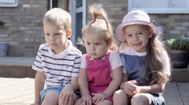 Three cute little Children enjoys delicious ice cream cone. Child eating watermelon popsicle. Kids Siblings snack sweets in Home Garden. Summer holiday Hot weather Sunny Day. Childhood, Food Candy.