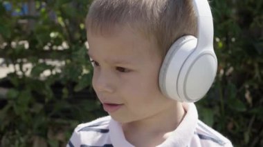 Portrait of Cute Little Boy With Headphones Listening to Music. Cheerful Carefree Childhood. Preschool Girl Feeling Free and Funky, Good Emotions Life. Child Listening to Music in Home and Dancing.