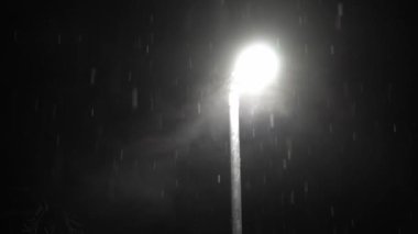 Birleşik Krallık 'taki ilk kar yağışı örtüsü kara arka planda. Gece Yolu 'ndaki Lambanın Işığında Düşen Kar Taneleri Kış, Yavaşça Düşen Kar Etkisi. Hava Durumu, Anomali, Acil Durum Konsepti.