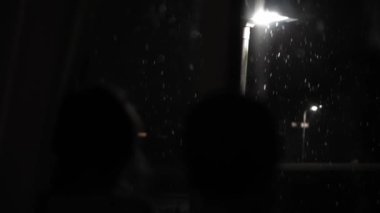 Birleşik Krallık 'taki ilk kar yağışı örtüsü kara arka planda. Gece Yolu 'ndaki Lambanın Işığında Düşen Kar Taneleri Kış, Yavaşça Düşen Kar Etkisi. Hava Durumu, Anomali, Acil Durum Konsepti.