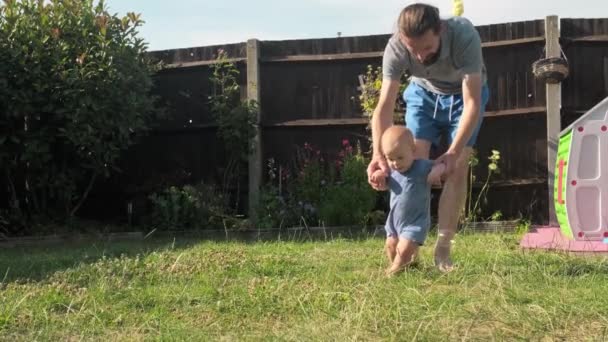 Baby Neemt Eerste Stappen Gras Vader Loopt Met Zoon Natuur — Stockvideo