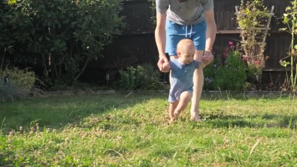 Bebé Los Primeros Pasos Hierba Dady Padre Camina Con Hijo — Vídeos de Stock