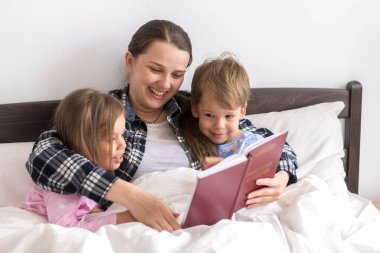 Mutlu bir aile. Sevgi dolu bir anne kızıyla birlikte yatıyor iki çocuk pijamaları yatakta ilginç hikayeler okuyor, anaokulunda gülümseyen bir kız çocuk peri masalının tadını çıkarıyor..