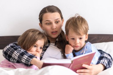 Mutlu bir aile. Sevgi dolu bir anne kızıyla birlikte yatıyor iki çocuk pijamaları yatakta ilginç hikayeler okuyor, anaokulunda gülümseyen bir kız çocuk peri masalının tadını çıkarıyor..