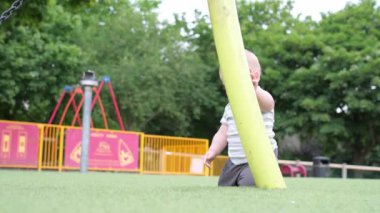 Mutlu aile piknik yapıyor. Küçük bebek yeşil çimlerde sürünüyor. Park yazında. Green Park 'ta oynayan kardeşler. Oyun salonunda aile eğlencesi ve neşe. Aktif oğul tarlada yalınayak sürünüyor..