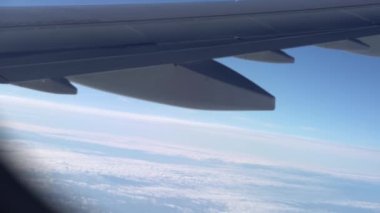 Kışın bulutlu bir günde uçağın motorlu kanadında uçan güzel manzaralı yolcu penceresinden kuş bakışı görüntü. Ulaşım, turizm, seyahat, uçuş, tatil konsepti