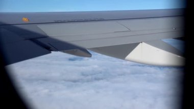 Kışın bulutlu bir günde uçağın motorlu kanadında uçan güzel manzaralı yolcu penceresinden kuş bakışı görüntü. Ulaşım, turizm, seyahat, uçuş, tatil konsepti