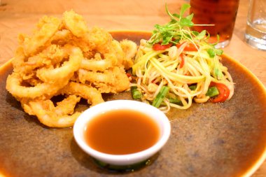 Tayland baharatlı papaya salatası ve tatlı soslu kızarmış kalamar halkaları..