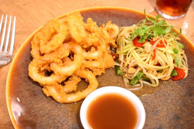 Tay baharatlı salata ve tatlı soslu kızarmış Calamari halkalarının üst görüntüsü..