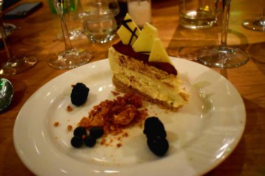 Passion meyve martinili cheesecake 'in yakın çekimi. Votka kaplı cheesecake, beyaz çikolatalı bal peteği nugget, beyaz tabakta vanilyalı dondurma..