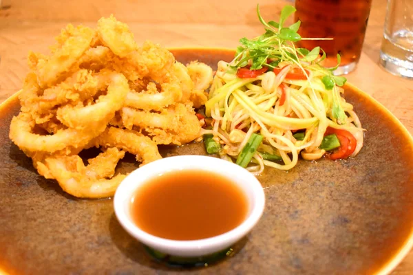 Tayland baharatlı papaya salatası ve tatlı soslu kızarmış kalamar halkaları..