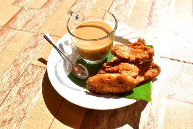 Tahta zemin üzerinde muzlu börek olan bir fincan kahve. Tayland kırsalında sabah yavaş yaşam tarzı.