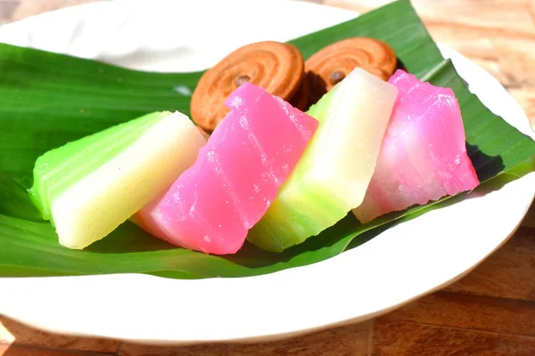 在绿色香蕉叶上特写多彩的蒸潘丹层泰国甜食和巧克力饼干 — 图库照片