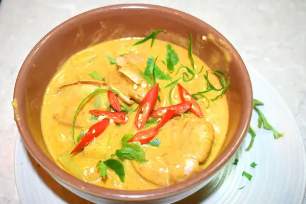 Thai food tradition, Spicy Panang Curry with King Prawns seasoning with red chili and Kaffir lime leaves on the top. Thai food tradition cooking at home.