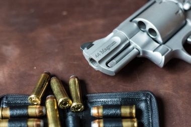 .44 magnum revolver gun with bullet on leather background personal defence