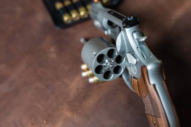 .44 magnum revolver gun with bullet on leather background personal defence