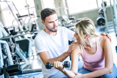 Sport man trainning woman exercise lifting weight in sport gym fitness gym