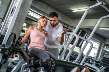 Sport man trainning woman exercise lifting weight in sport gym fitness gym