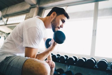 Spor salonundaki dambılı kaldıran akıllı sporcu sağlıklı bir yaşam tarzı.