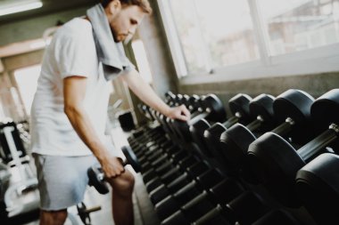 Spor salonundaki dambılı kaldıran akıllı sporcu sağlıklı bir yaşam tarzı.