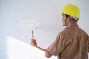 Men paint indoor color with roller paint on white background