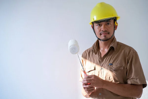 stock image Painter man painting on white wall interior working new house with copyspace