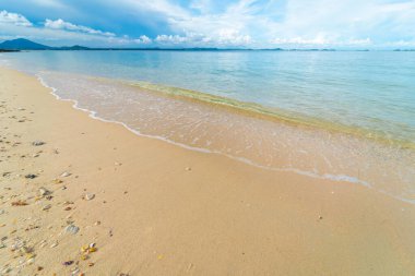 Doğa sahnesi deniz dalgası plaj sükuneti bulutlu mavi gökyüzünü yaz tatili arka planına yerleştirir