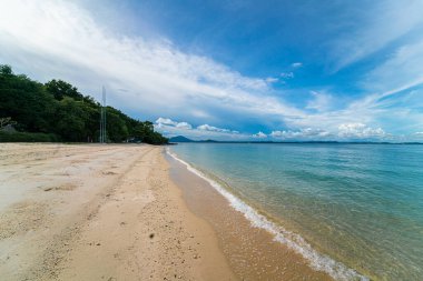 Deniz sahili dalgaları beyaz kumsalda mavi gökyüzü bulutlarına karşı yaz tatili