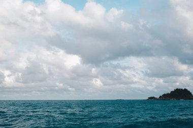 Deniz kıyısı kayalık plaj günbatımı mavi gökyüzü bulutlu deniz manzaralı