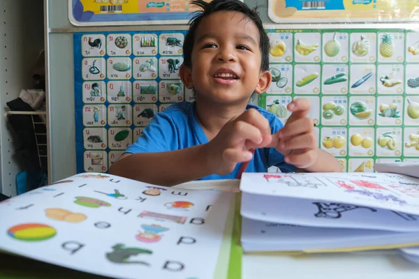 stock image Happy kindergarten boy drawing pencilo color homework in home education concept