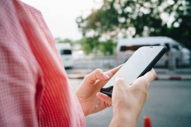 Genç, güzel, sarışın, yaz şapkası takan, şehirde mutlu kadınlar için akıllı telefon kullanan bir kadın.