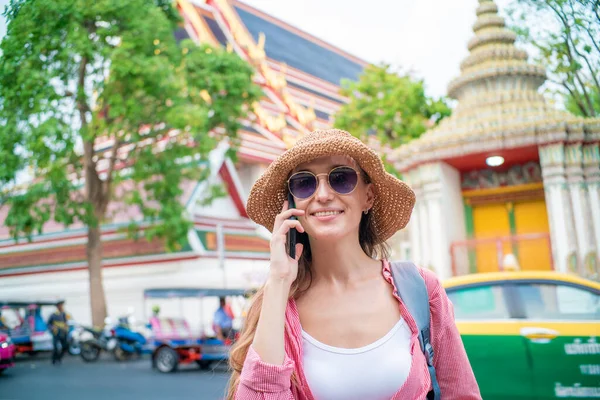아름다운 금발의 모자를 도시의 여성들 거리에서 스마트폰을 사용하며 휴가중이다 — 스톡 사진