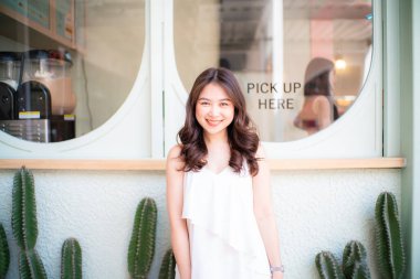 Güzel Asyalı kadın kahve dükkanına yerleşiyor şehir seyahatinde, kafede dinleniyor.