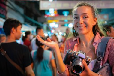 Tek başına seyahat eden turist kadınlar gece vakti Bangkok Tayland 'da fotoğraf çekerler.