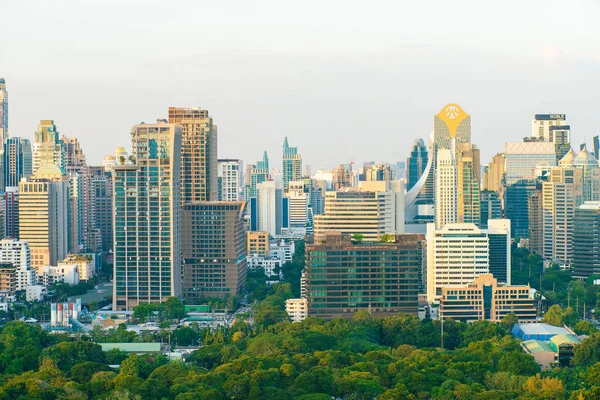 Bangkok şehrinde ağaç parkı olan modern ofis binası ve otel mavi gökyüzüne karşı Tayland bulutu