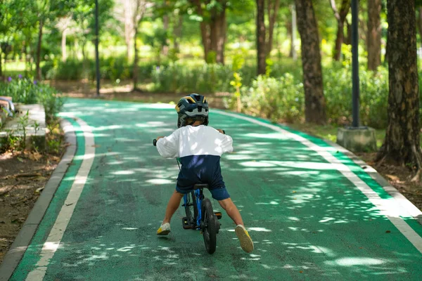 小さな幼稚園の少年は公園の野外活動で自転車に乗る — ストック写真
