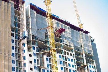 Vinç dairesi olan inşaat alanı. Yükselen bina gayrimenkul endüstrisi.