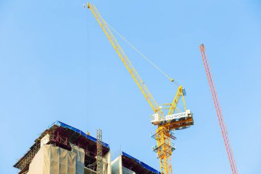 Vinç dairesi olan inşaat alanı. Yükselen bina gayrimenkul endüstrisi.